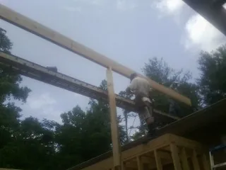 Carpenter setting a ridge beam over a new addition frame — Ice Dam Removal by Roofing Brothers in Michigan City