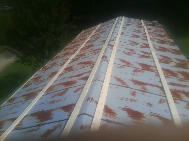 Rusted metal roof panels with new wood purlins before replacement — Storm Damage Roof Repair in Michigan City by Roofing Brothers