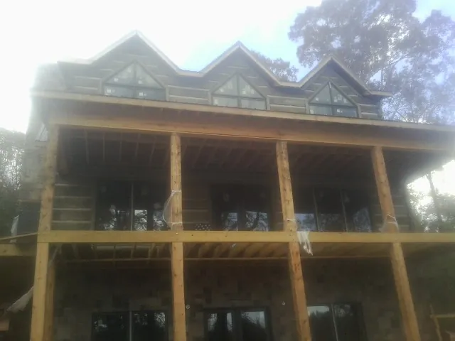 Dormers and porch framing on a large log home under construction — Roof Coating work by our crew in Michigan City