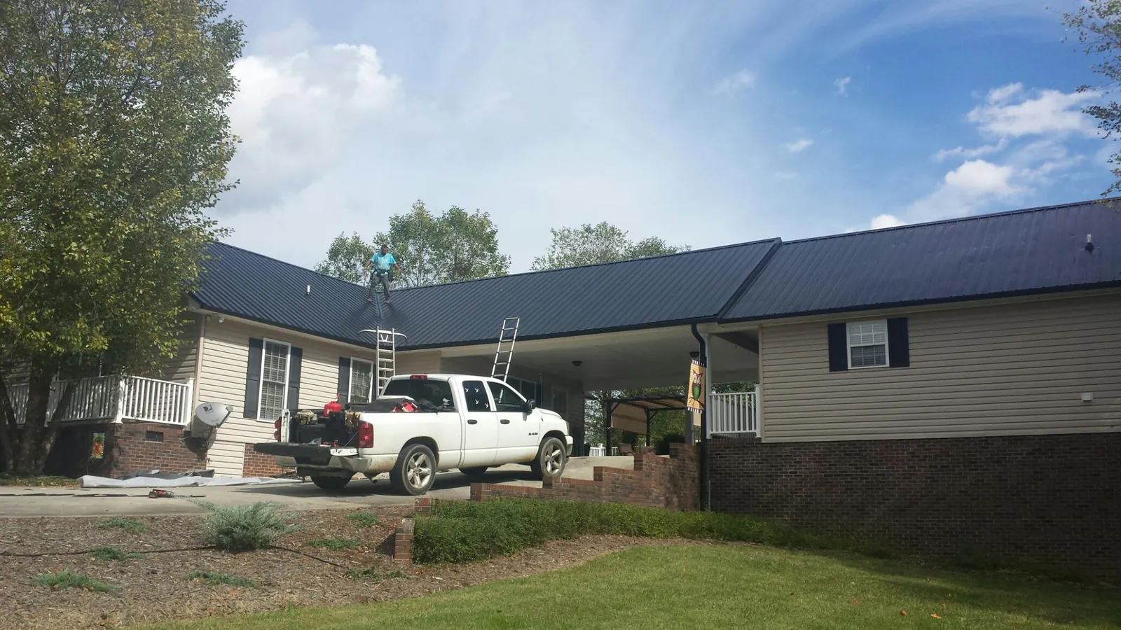 Black metal roof over a home and attached breezeway with ladders set in Michigan City