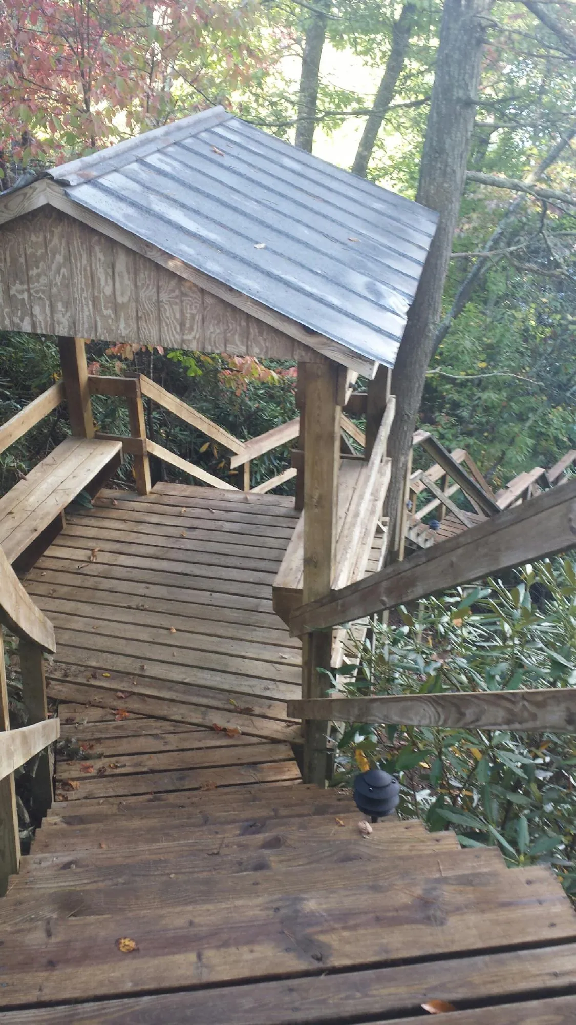 Metal roofed shelter over wooden steps on a wooded walkway — Skylight Repair & Installation work by our crew in Michigan City