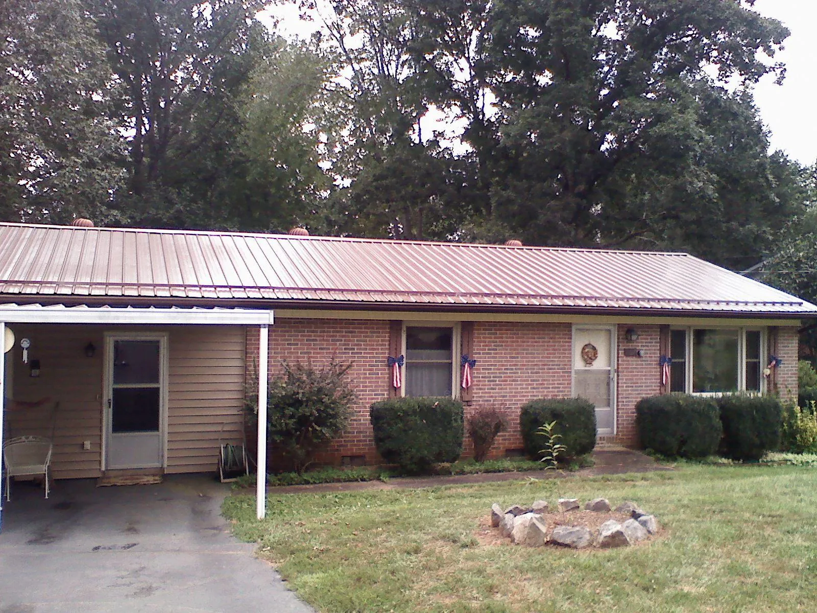Bronze metal roof and carport on a brick ranch home — Roof Repair work by our crew in Michigan City